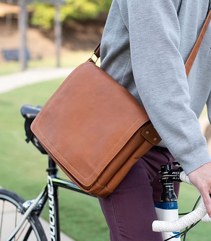 leather messenger bag being worn while riding a bike through downtown